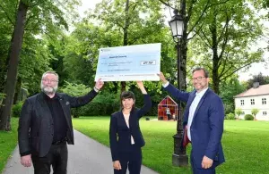 Das Bild zeigt den Parlamentarischen Staatssekretär Florian Pronold bei der Förderscheckübergabe mit der Bundestagsabgeordneten Bela Bach und dem Bürgermeister Dr. Alexander Greulich.